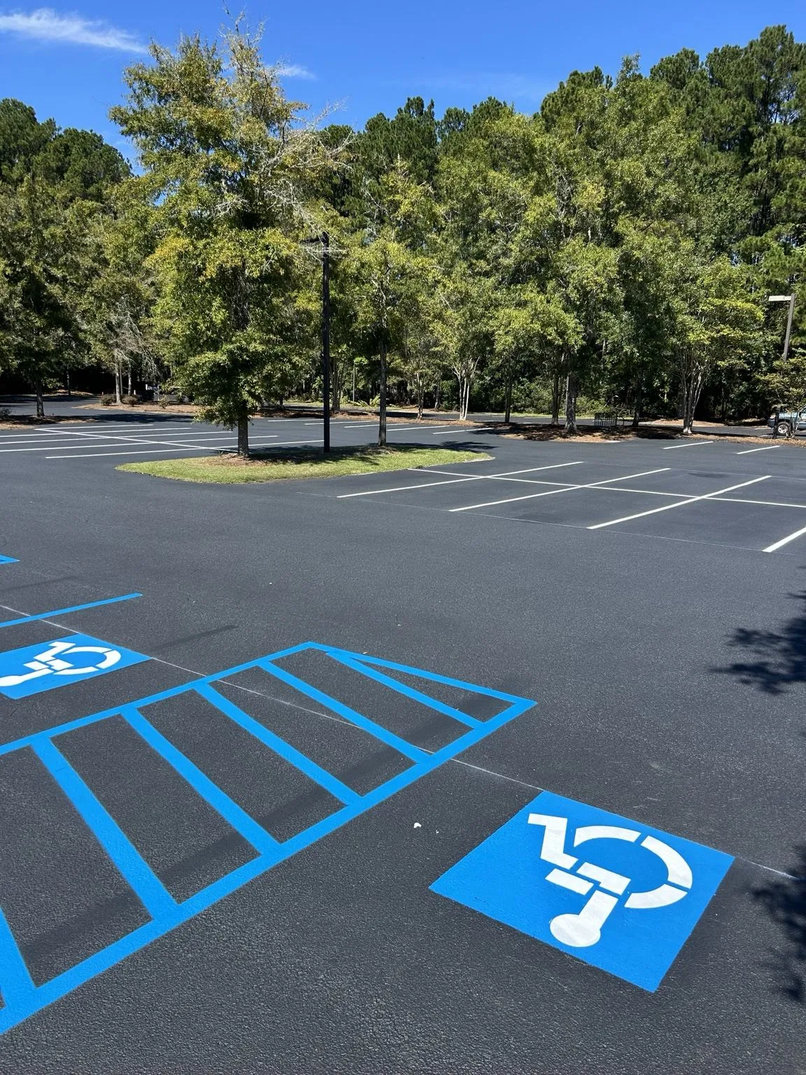 Bright blue ADA accessibility symbols and striped access aisle on a freshly maintained lot