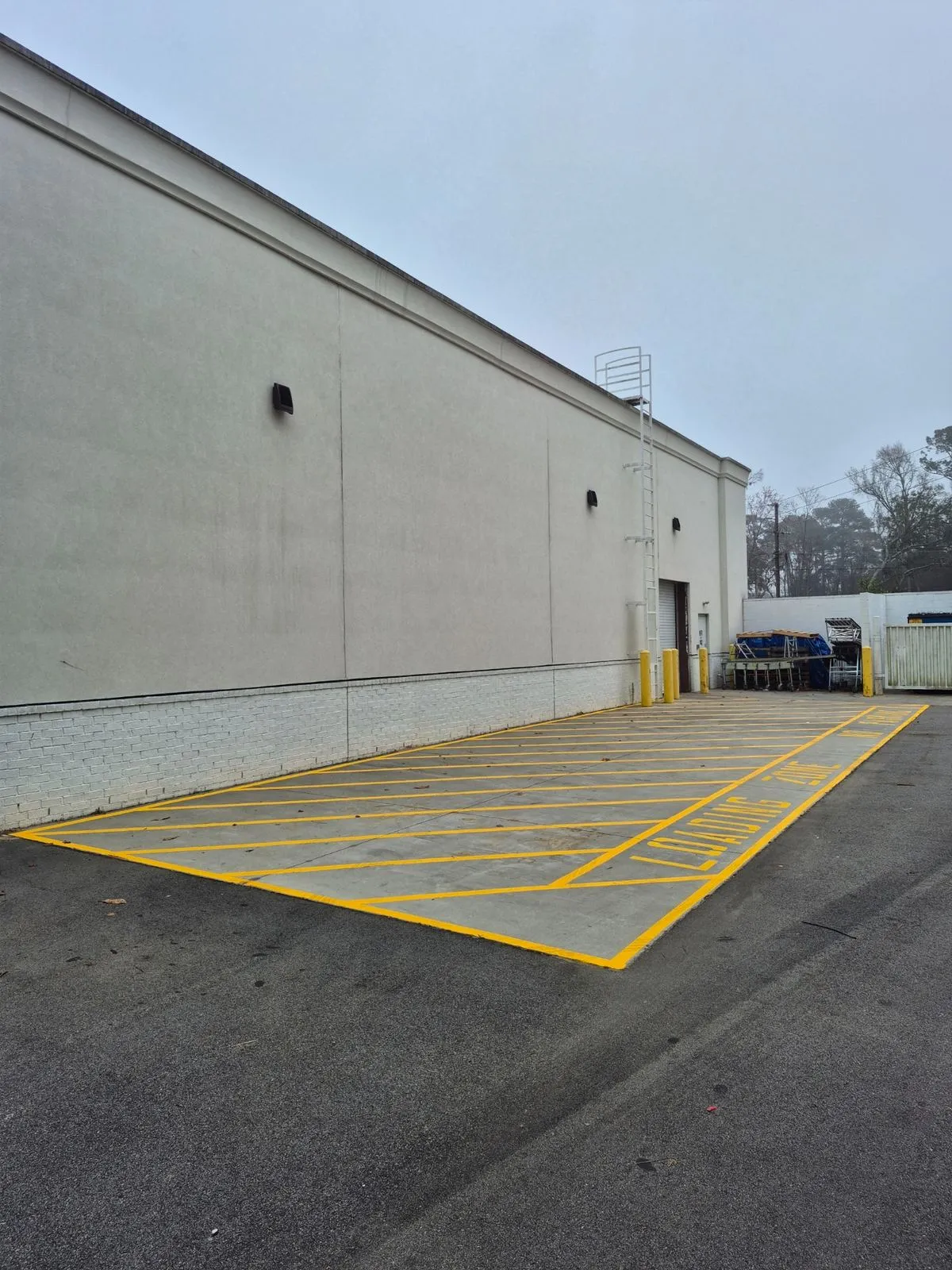 Yellow crosshatched loading zone marking behind a commercial building