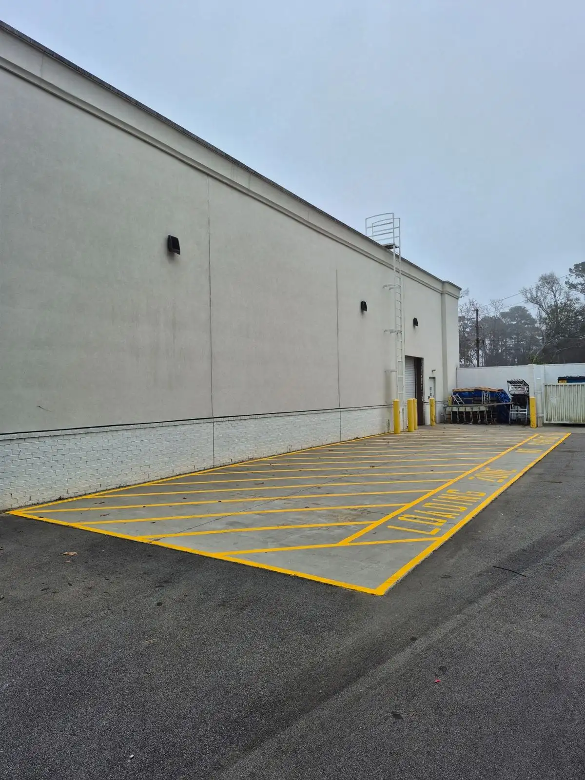 Yellow crosshatched loading zone marking behind a commercial building