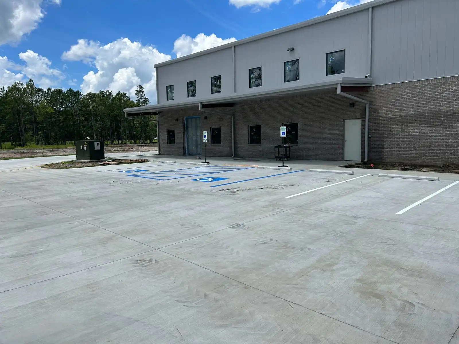 New construction concrete parking area with blue ADA stalls and white parking lines