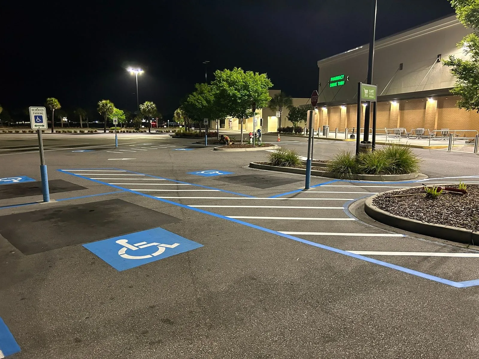 Shopping center parking lot restriped at night with new ADA markings