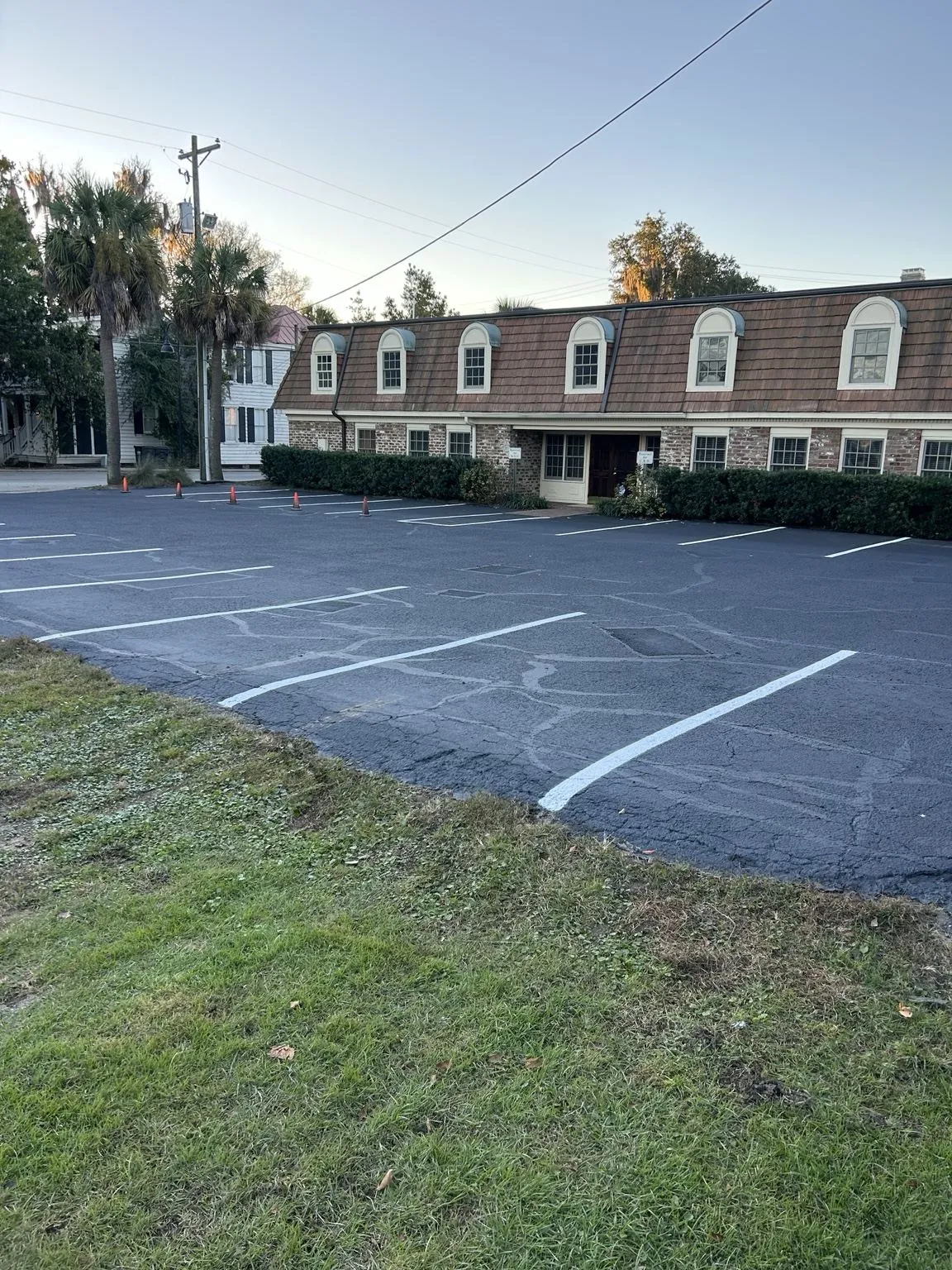 Office parking lot restriped with fresh white stall lines over maintained asphalt